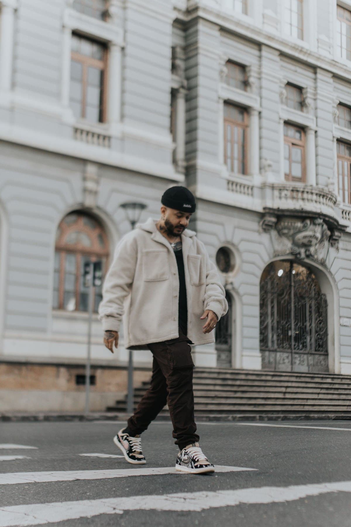Relaxed city style: walking in sneakers across a quiet street